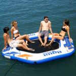 Couples using 10' Hex Dock Inflatable Island in blue, gold, and white